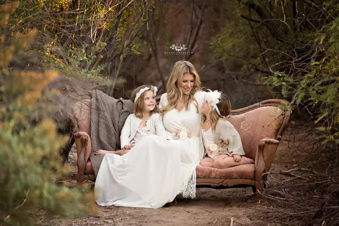 مادر و دو دختر در لباس سفید روی صندلی قدیمی در طبیعت