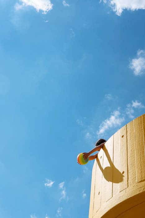 یک عکس روشن و هوا از کودکی که در برج مقابل آسمان آبی بازی می کند ، قانون یک سوم در عکاسی را نشان می دهد