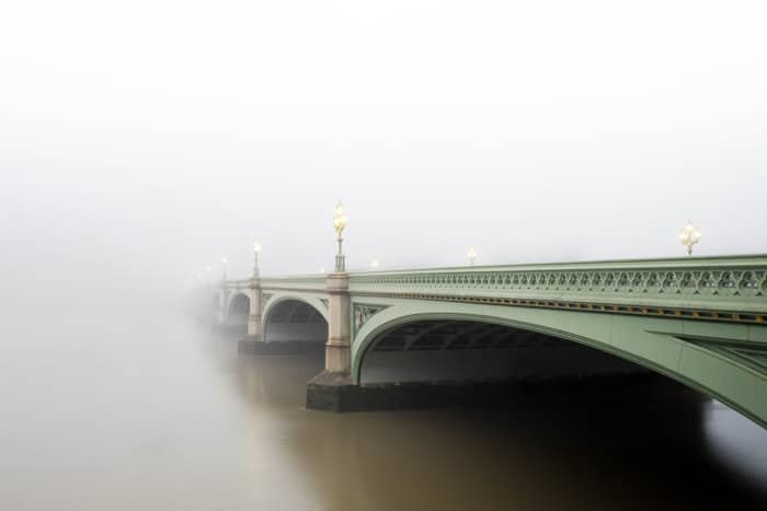 عکس جویی که از یک پل سبز که در مه ناپدید می شود