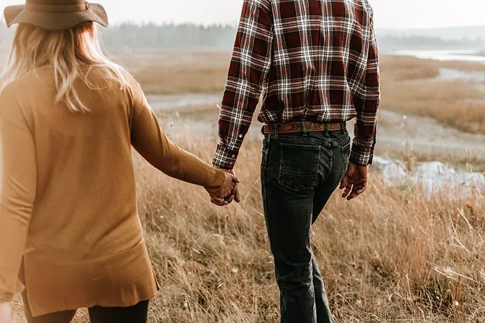 ژست دست در دست زوج هنگام پیادهروی در طبیعت برای عکاسی عاشقانه