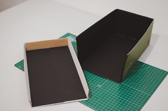 چسباندن کاغذ سیاه به جعبه کفش برای ساخت یک پروژکتور خانگی