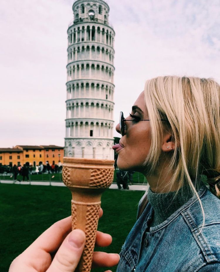 عکسی از دختری که ژست گرفته تا به نظر برسد که در حال لیسیدن برج کج پیزا در قیفی بستنی است