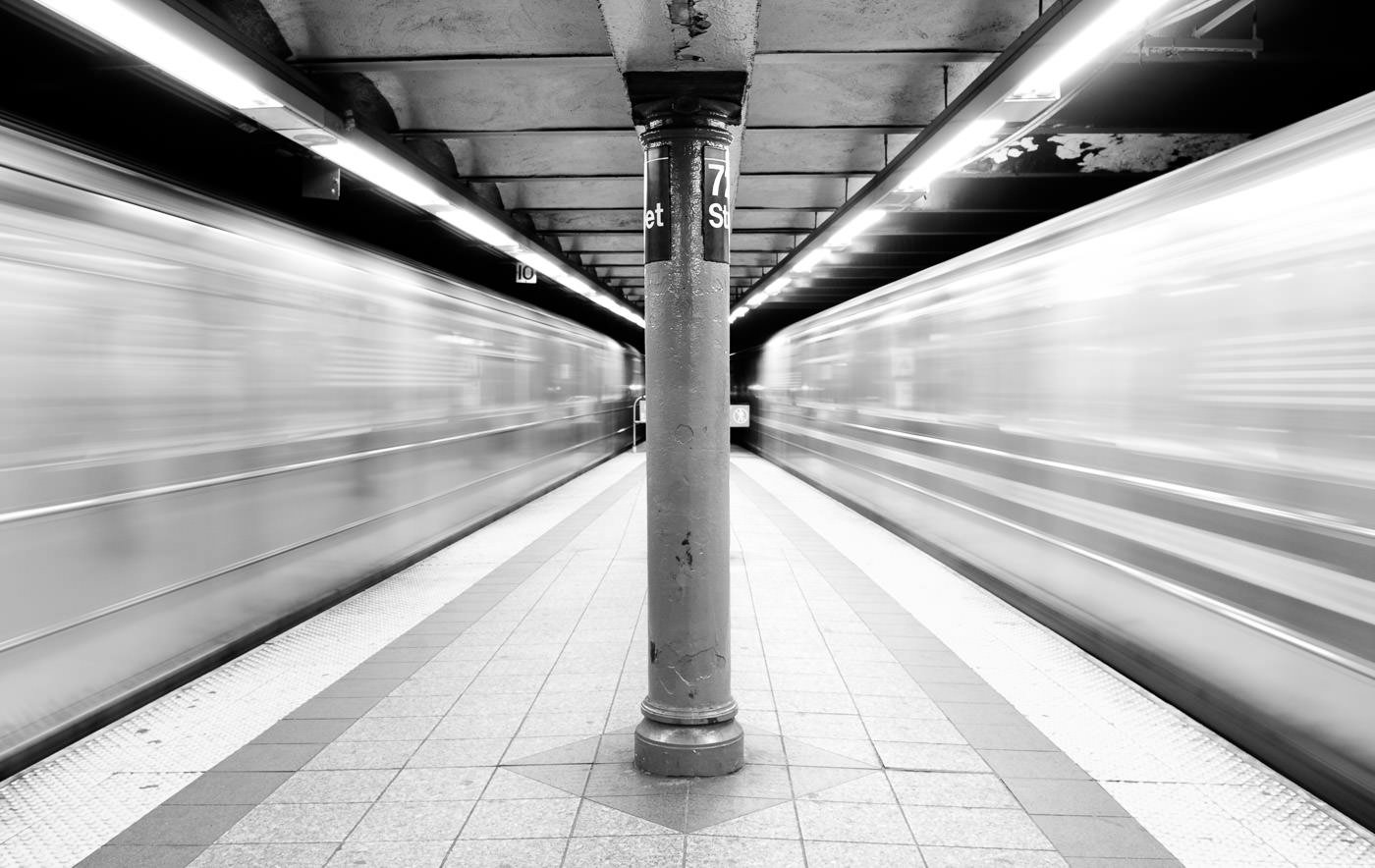 قطارهای متروی نیویورک از هر دو طرف سکو به سرعت در حال عبور هستند و فضای تاری در اطراف ایجاد می کنند