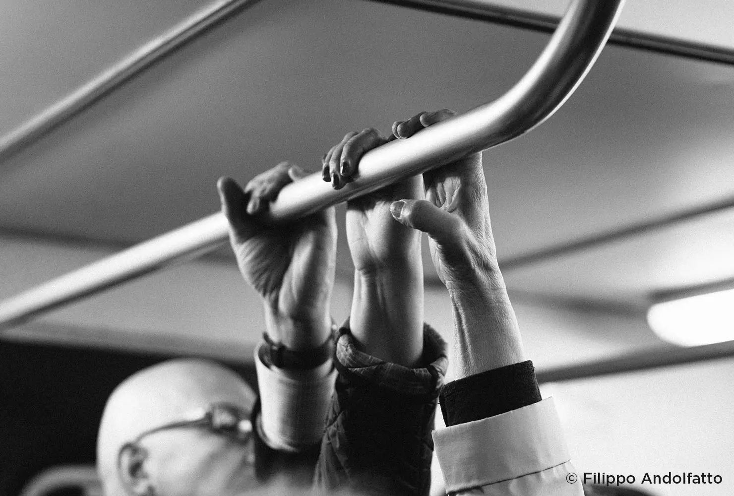 عکاسی خیابانی سیاه‌وسفید دست‌ها در مترو