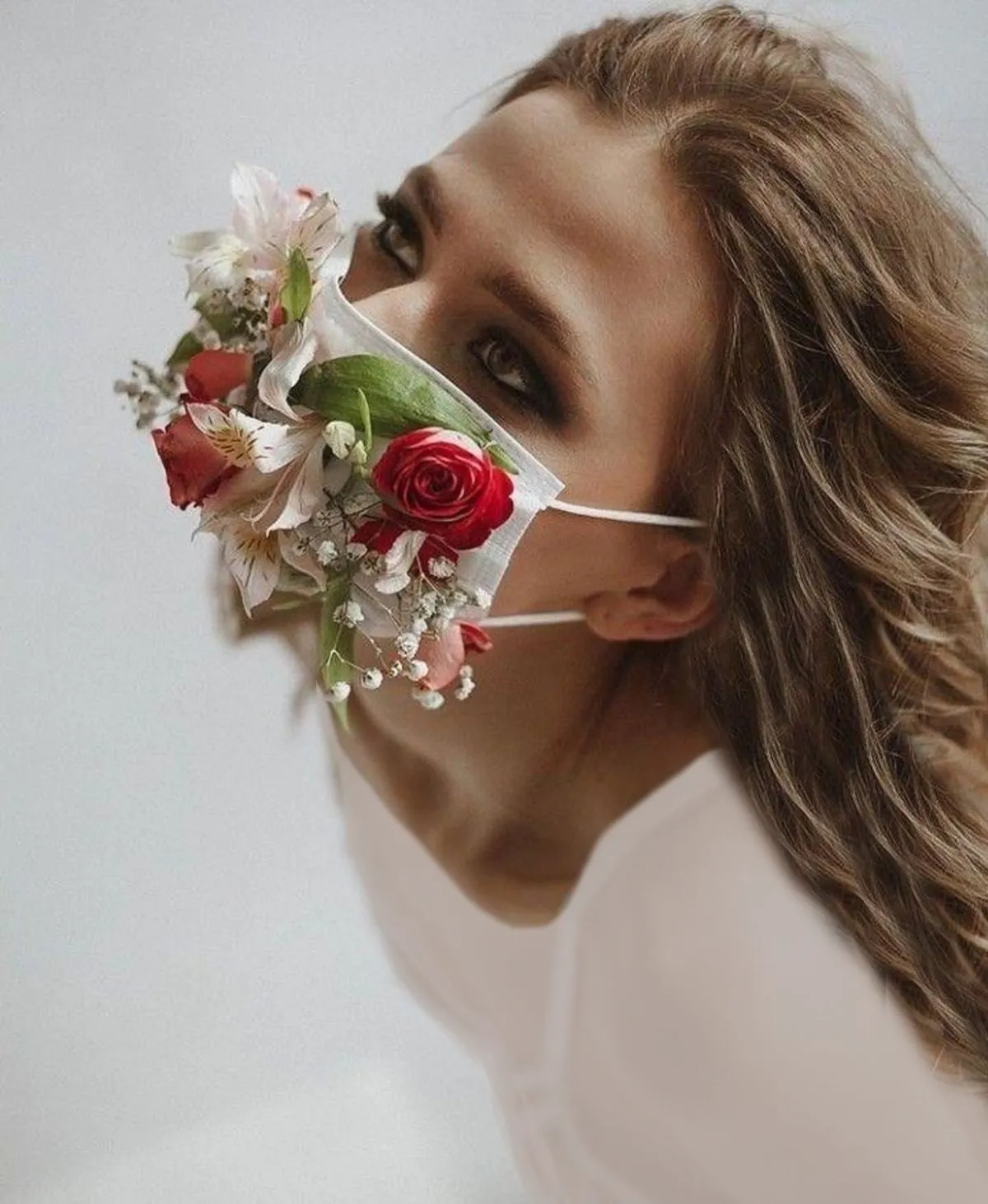 پرتره زن با ماسک پوشیده از گلهای قرمز و سفید به سبک خلاقانه و مفهومی