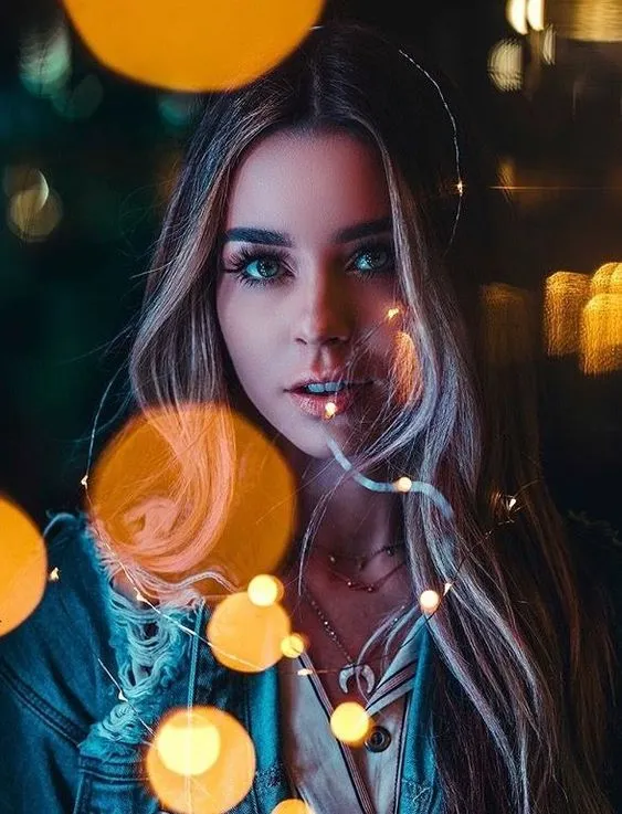 پرتره دختر جوان با افکت بوکه و نورهای محو در پسزمینه