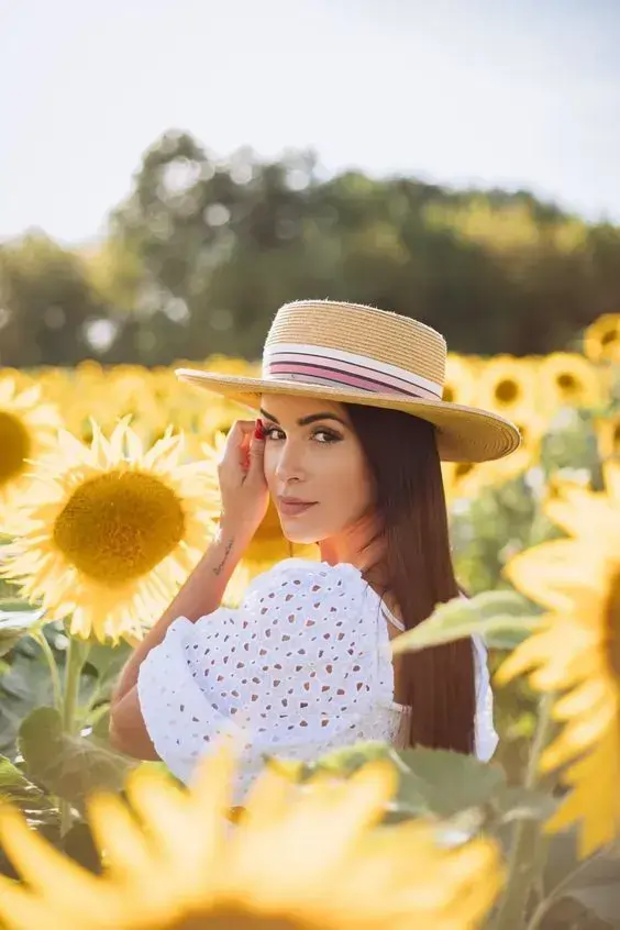 پرتره زنانه در مزرعه آفتابگردان با کلاه حصیری