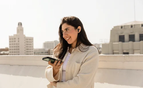 شخصی در حال مکالمه با تلفن همراه با استفاده از هندزفری بی‌سیم JBL Tune Flex