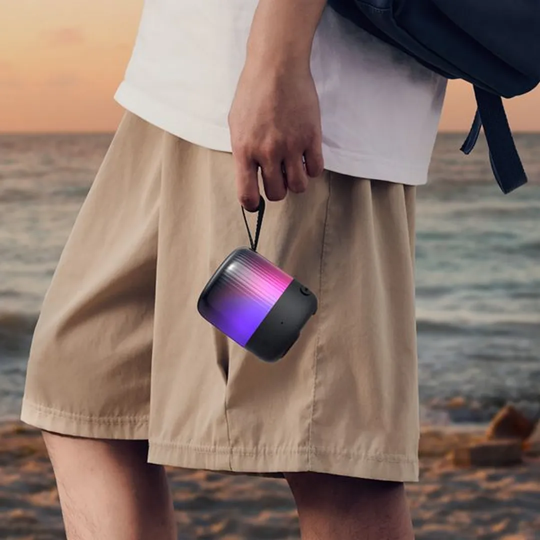 اسپیکر Soundcore Glow Mini در حال حمل در دست کنار ساحل